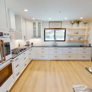 A bright and modern kitchen featuring white cabinetry and a spacious layout.