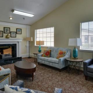 A cozy living room with sofas, a fireplace, and decorative elements.