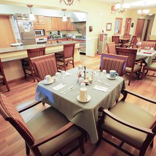 A cozy dining area and kitchen with a table set for a meal.