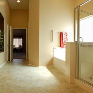 A modern bathroom featuring a glass-enclosed shower and a built-in bathtub with towels hanging nearby.