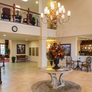 An elegantly designed hotel lobby featuring a grand chandelier, comfortable seating areas, and stylish decor.
