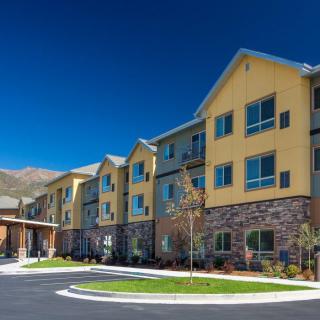A modern residential apartment building with a colorful facade under a clear blue sky.
