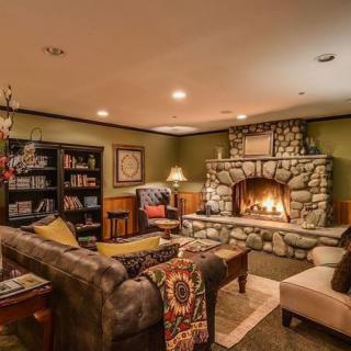 A cozy living room with a stone fireplace and a well-stocked bookshelf creates a warm and inviting atmosphere.