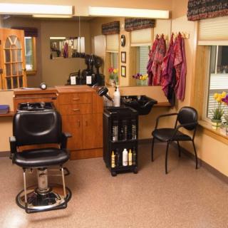 A cozy hair salon interior with a barber chair, mirrors, and hair styling equipment.