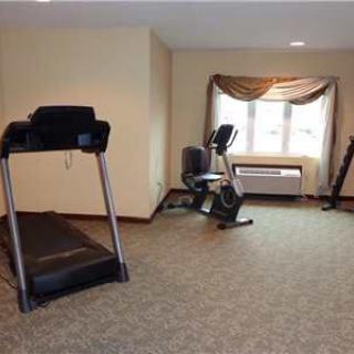 A small gym space with a treadmill and an exercise bike by the window.
