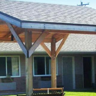A building with a wooden porch and shingled roof.
