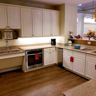 A modern kitchen with white cabinets and an integrated oven.