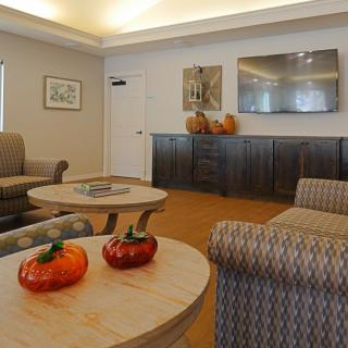 A cozy living room with autumn-themed decorations, including pumpkins on the tables.