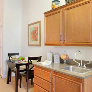 A cozy kitchen with wooden cabinets and a small dining area featuring a table and chairs.