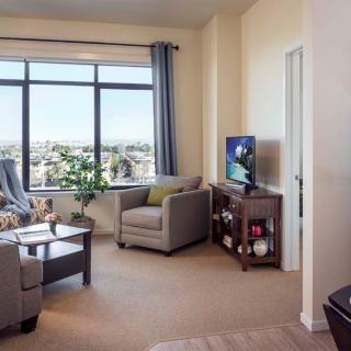 A modern and cozy living room with large windows offering a city view.
