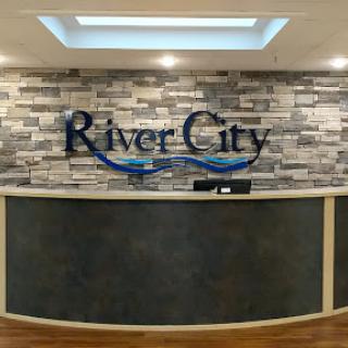 A modern reception area for River City with a stylish stone wall design.
