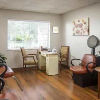 A cozy salon waiting area with chairs and a hair dryer.