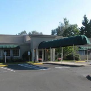 A commercial building with an awning-covered entrance and adjacent parking spaces.