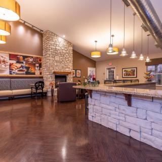 A modern lounge area with a bar, stone walls, and warm lighting.