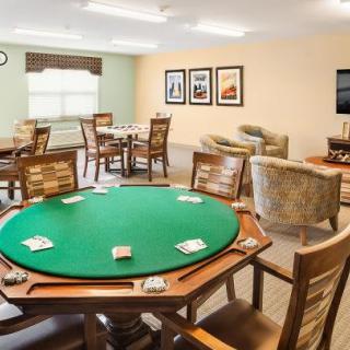 A spacious game room featuring a poker table with cards and comfortable seating.