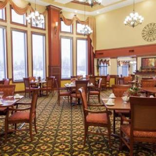 An elegant dining room with wooden furniture and large windows, offering a cozy atmosphere.