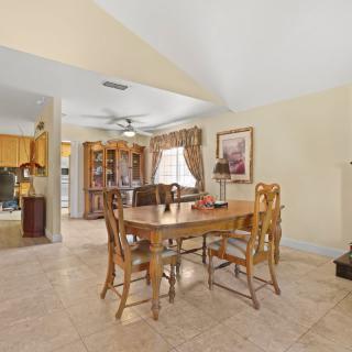 Cozy dining area with a wooden table and chairs, featuring homey decor and ample natural lighting.