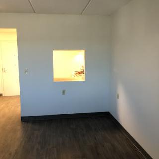 An empty room featuring a small window and minimalist design.