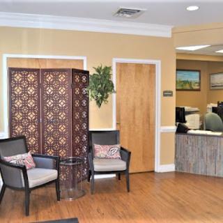 A cozy waiting area in an office featuring stylish chairs, a decorative screen, and a welcoming atmosphere.