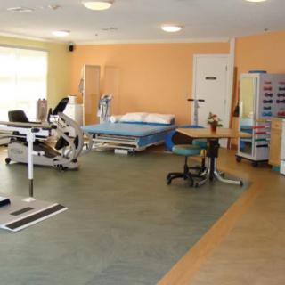 A rehabilitation center room equipped with exercise machines and therapy equipment.