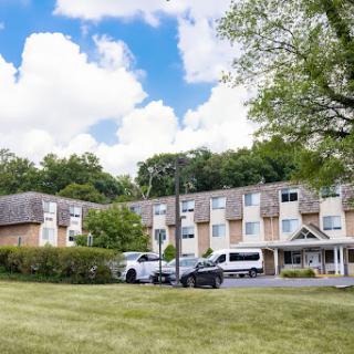 A view of a hotel surrounded by lush greenery and blue skies.
