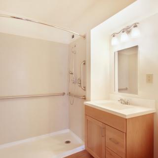 A minimalist bathroom with a shower and vanity area.