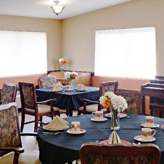 A cozy dining area with elegantly set tables and floral centerpieces.