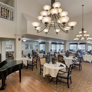 An elegant dining area with chandeliers and a grand piano.