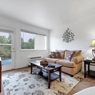 A cozy living room with a sofa, coffee table, and soft lighting.