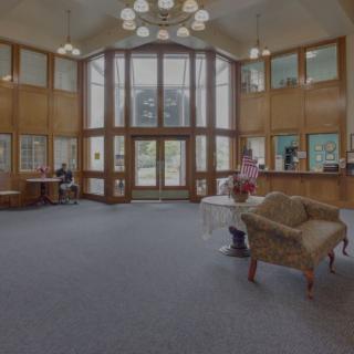 An inviting lobby area with large windows, comfortable seating, and a reception desk.
