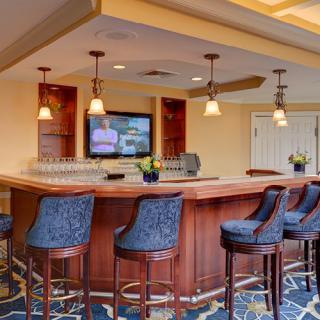 A modern bar interior with seating and a television.
