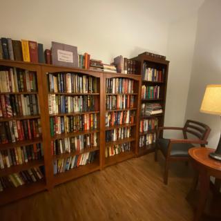 A cozy reading room with bookshelves filled with books and a warm lamp.