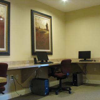 A quiet office space with computers and seating available at desks.