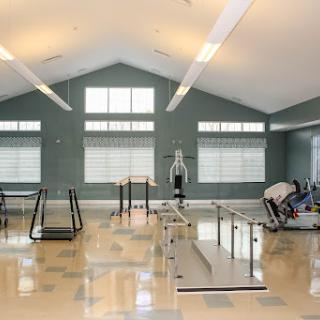 A spacious and well-lit gym area equipped with various fitness machines and exercise stations.