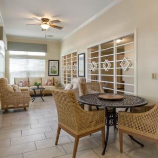 A cozy living space featuring wicker furniture and an organized bookshelves display.