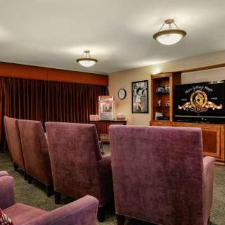 A cozy home theater setup with comfortable seating and a projector screen.