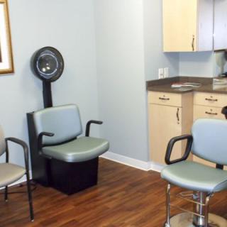 A small hair salon with chairs and a hair drying station.