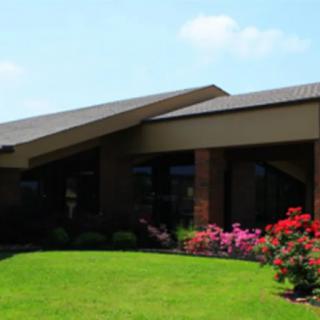 A modern house with a well-maintained lawn and colorful flower garden.