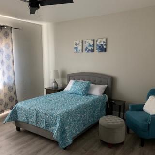 A cozy bedroom featuring a blue color scheme with matching bedspread and wall art.