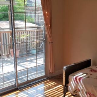Sunlit room with sliding glass doors leading to a wooden deck.