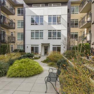 Modern apartment building with a landscaped courtyard and seating area.