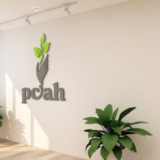 A modern logo featuring a green plant motif on a minimalist wall, complemented by indoor foliage.