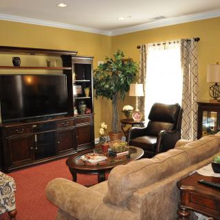 A cozy living room featuring a large television, comfortable seating, and stylish decor.