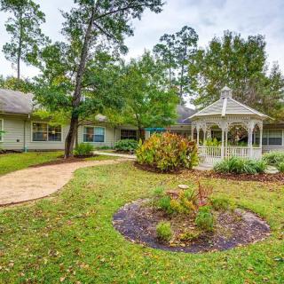 A charming house with a landscaped garden and a gazebo surrounded by trees.