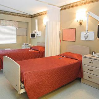 A hospital room with two beds and medical equipment.
