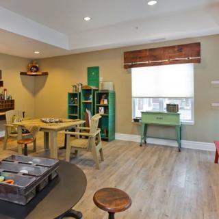 A cozy room with wooden floors, featuring a variety of furniture and decorative items.