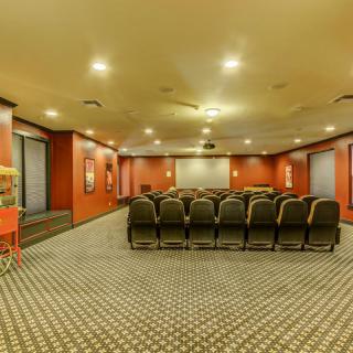 A theater-style conference room with rows of seating and a large projection screen.