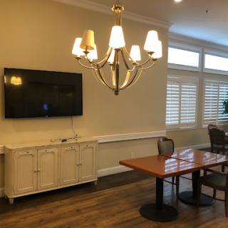 A cozy living space featuring a chandelier, a television, and a dining table.
