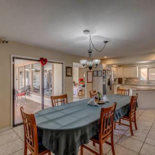 A bright and inviting dining area with a large table and comfortable chairs, perfect for family gatherings.
