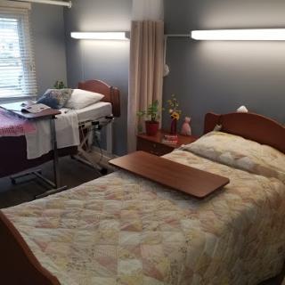 A well-arranged hospital patient room featuring two beds and a warm atmosphere.